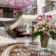 Винтовая лестница в белоснежном лобби отеля, украшенном дизайнерскими люстрами Masiero